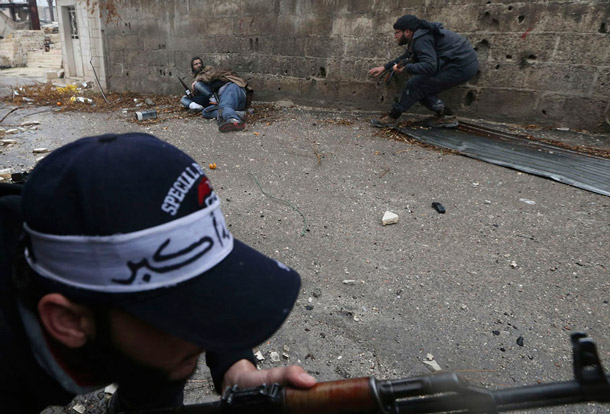 Rebel fighters lie on the ground after being shot by sniper fire during heavy fighting in the Ain Tarma neighborhood, Damascus. | Goran Tomasevic, Reuters