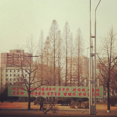 In what's considered to be the first photo posted live from North Korea on Instagram, a man walks in Pyongyang under a roadside banner referring to North Korea’s controversial Feb. 12 nuclear test. | Jean H. Lee / AP Photo